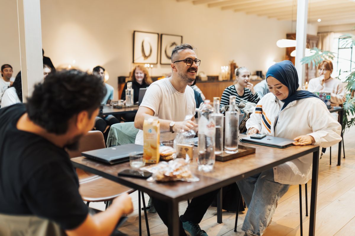 People sitting at a table working on laptops during a team meeting