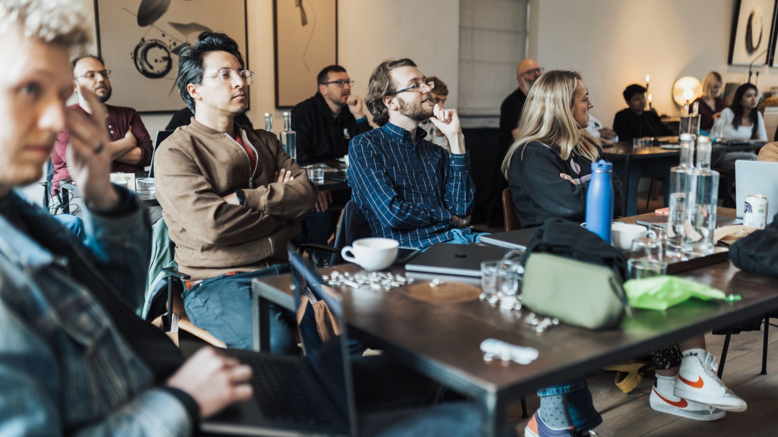 Diverse group of adults attending an educational seminar, focused on a presentation inside a modern conference room.