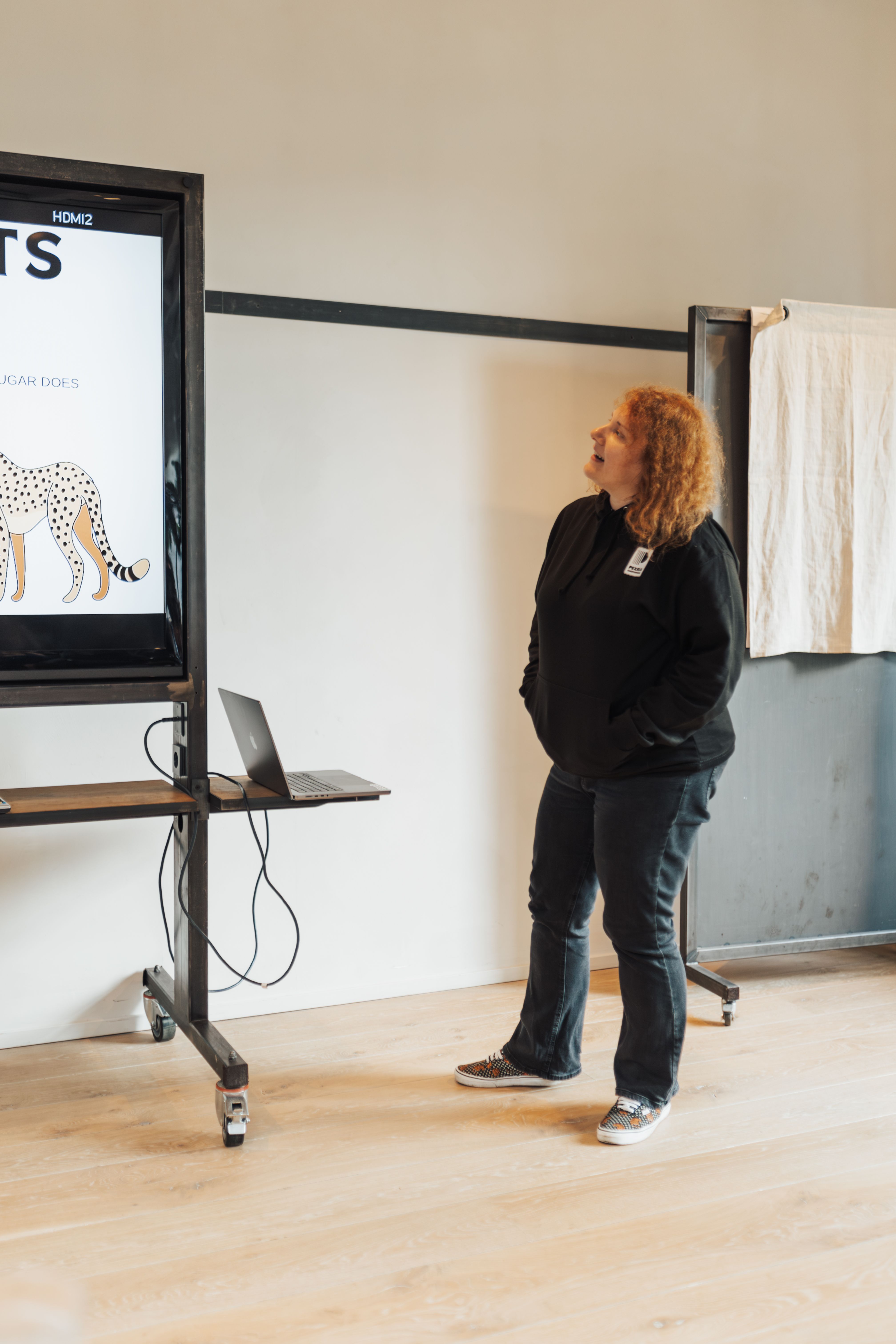 Woman presenting in a contemporary office setting with a digital display.