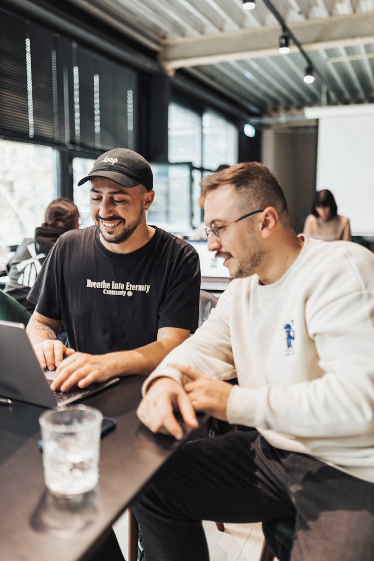 Young Men Looking At The Laptop Screen And Smiling 