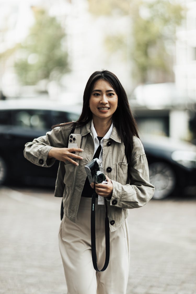 Portrait Of Woman Holding A Camera On A Street