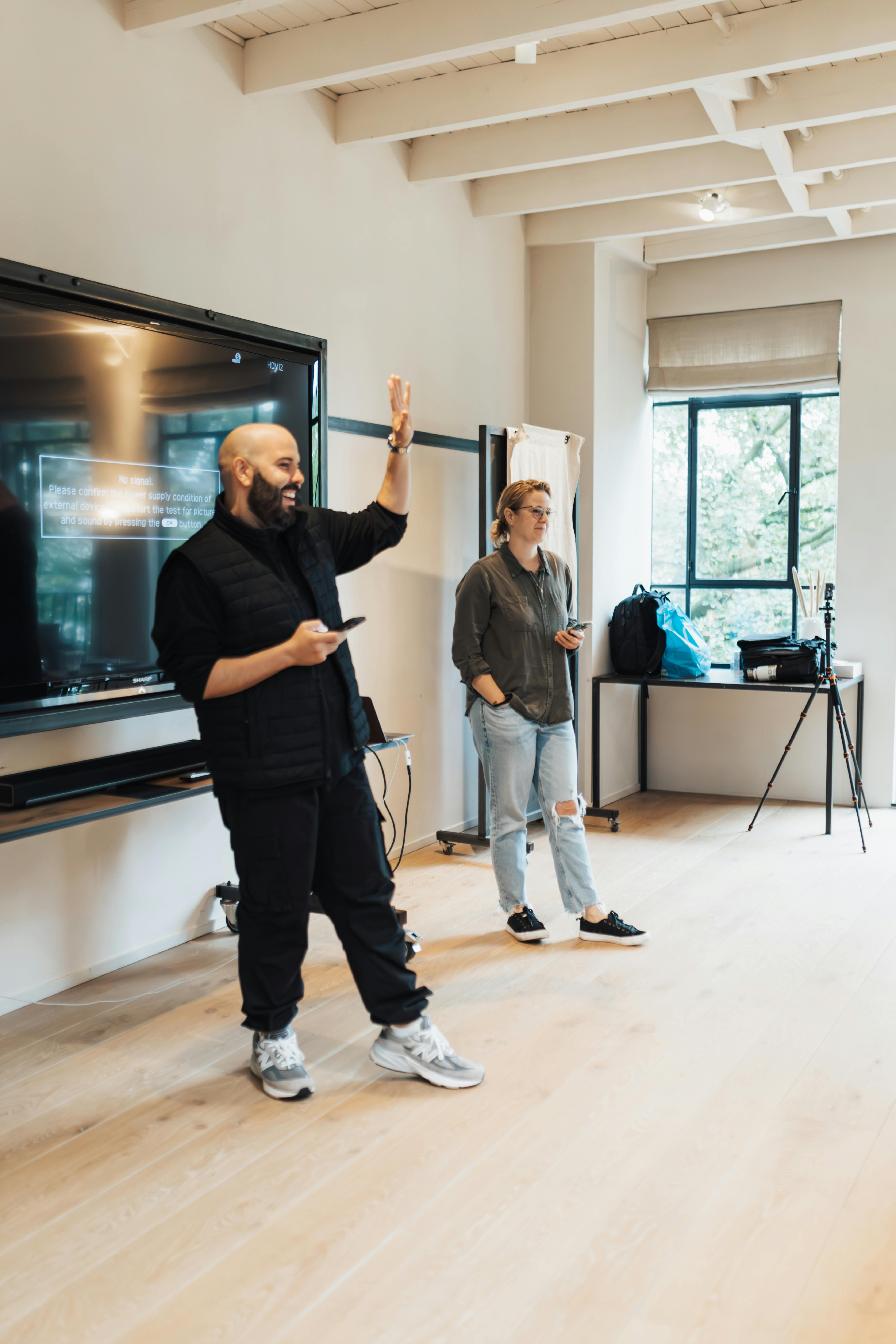 Business professionals engaging in an interactive office presentation with a large TV.