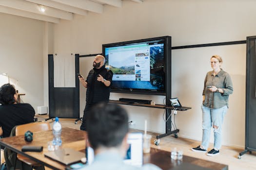 A team presentation in an office with a screen showcasing work-related material.