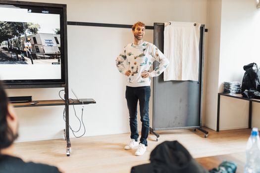 Happy man giving an engaging office presentation using a digital screen, fostering a positive work environment.