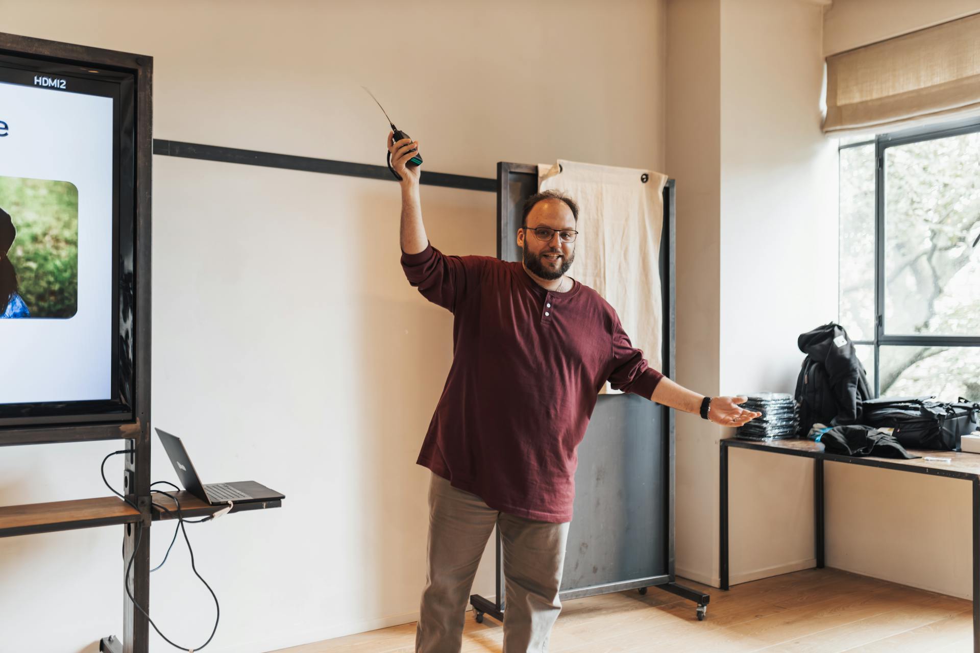 Man Presenting with Remote in Raised Arm