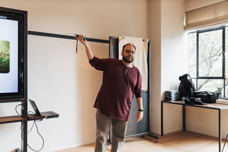 Man Holding Remote And Presenting In Meeting