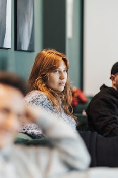 Casual group meeting indoors with attentive participants engaging in discussion.