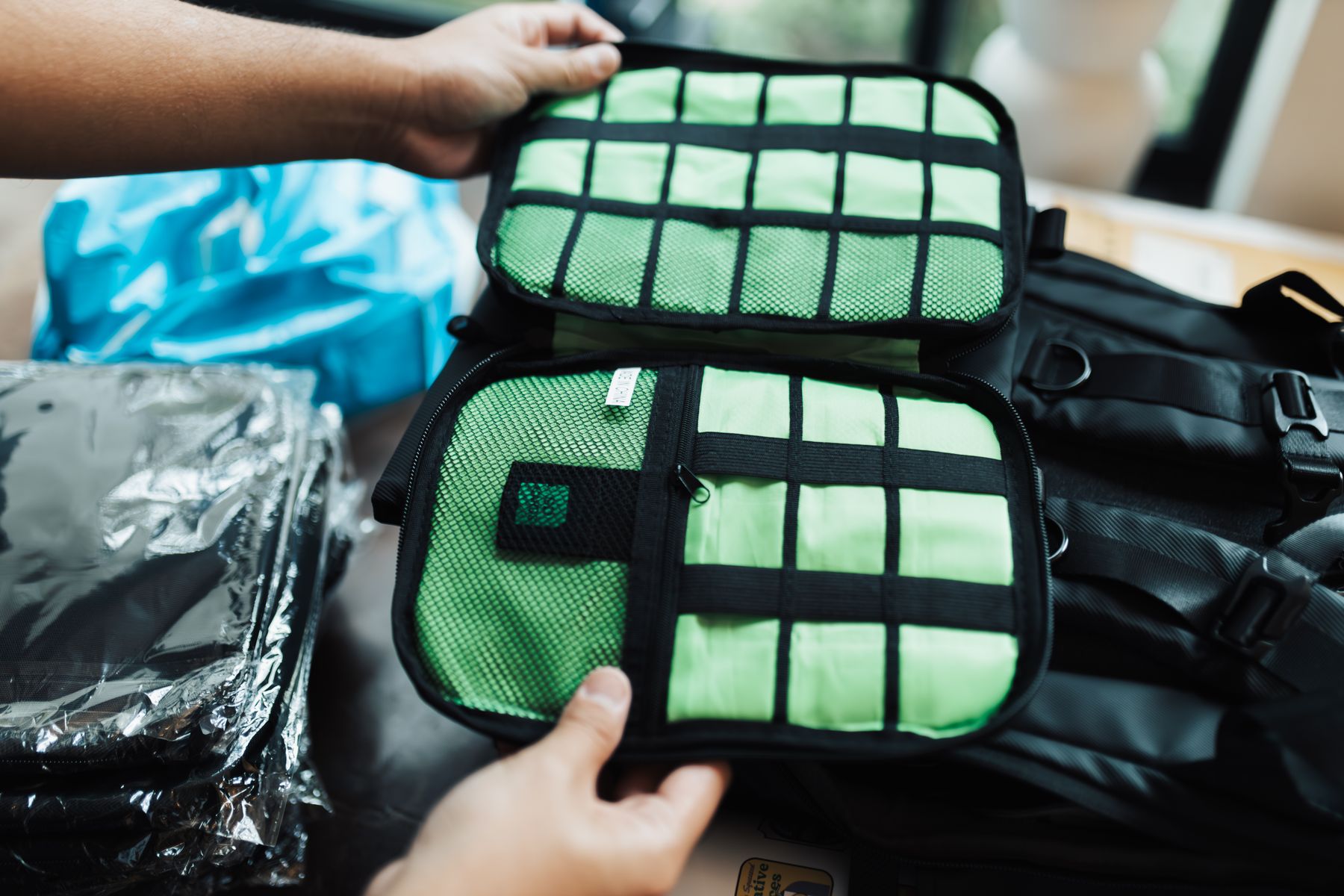 Hands organizing travel pouches and packing compartments for a trip