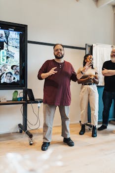 A diverse group presenting during a meeting in a modern office setting with a projector.