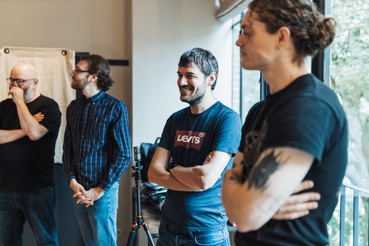 A group of adults engaging in a casual team meeting in an office space.