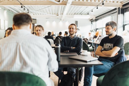 Group of adults engaging in a collaborative discussion at a business meeting in a modern office setting.