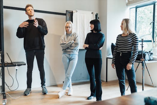 A group of four adults engaged in a presentation and discussion in a modern office environment.