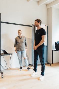 A man and woman engage in a lively discussion during a casual training session in a modern office setting.