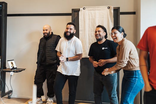 Four friends laughing and enjoying a cheerful indoor gathering, showcasing camaraderie and joy.