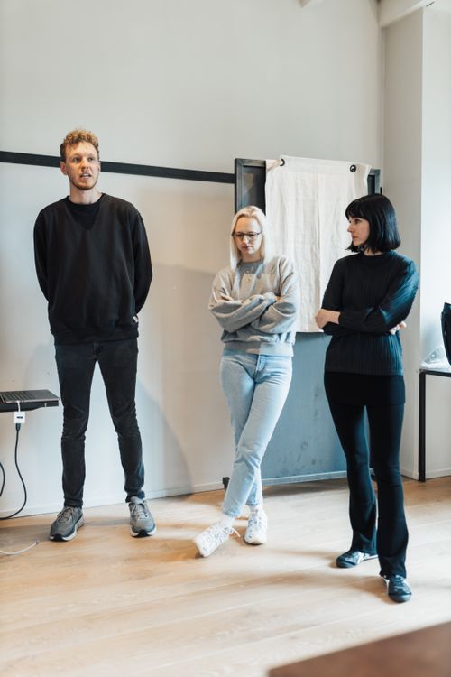 Free Three young adults in a casual office giving a team presentation. Indoor setting. Stock Photo