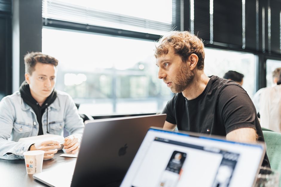 Two young adults engage in a focused discussion during a brainstorming session in a modern office.