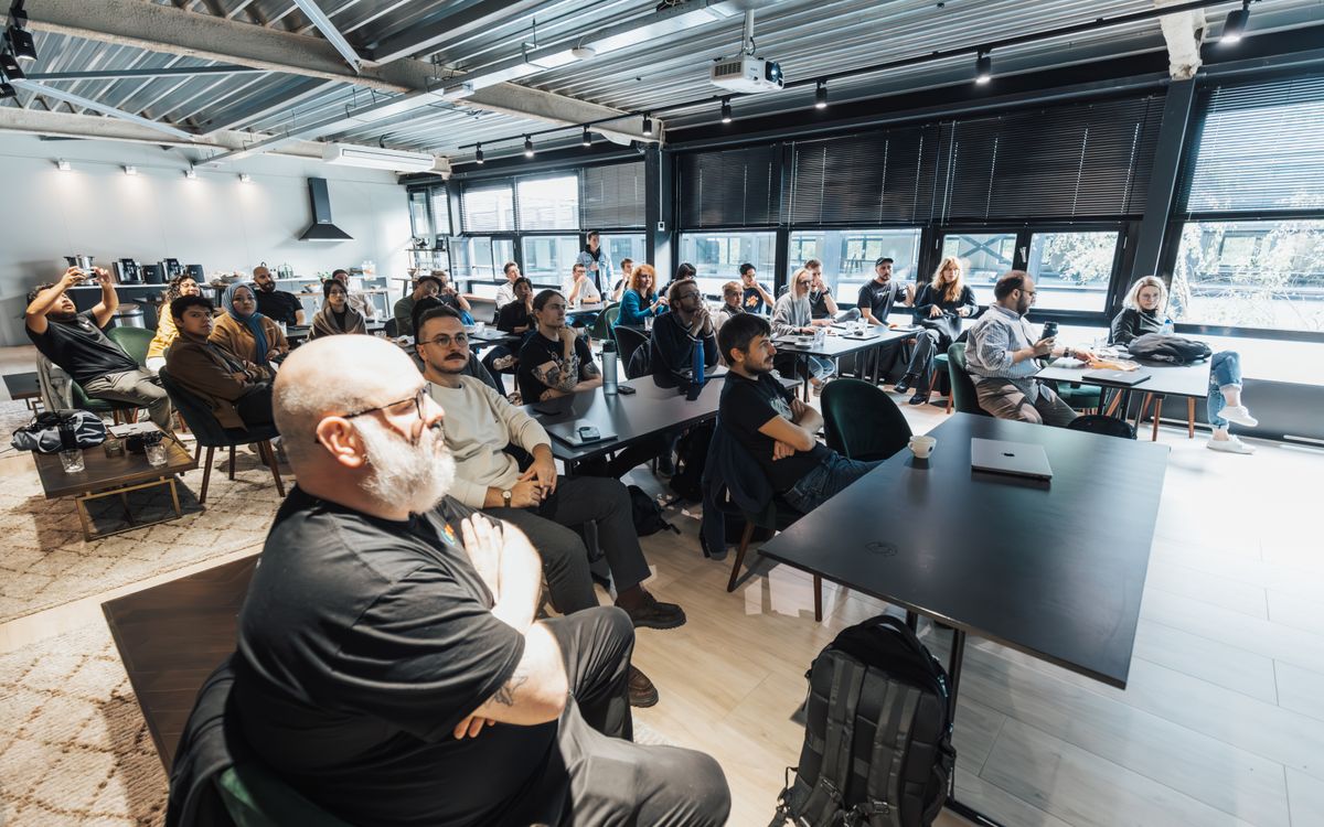 A diverse group of professionals attentively listening during an indoor business meeting in a modern conference room.