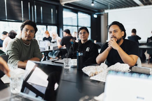 Professionals engaged in a meeting in a modern office space discussing business strategies.