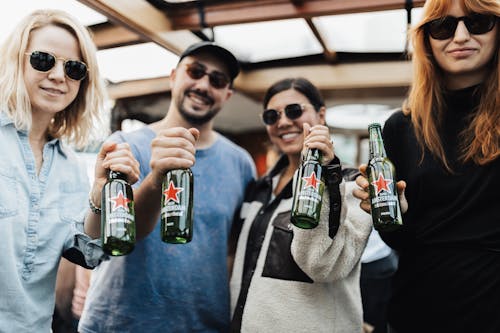 Four People Holding Beer Bottles 