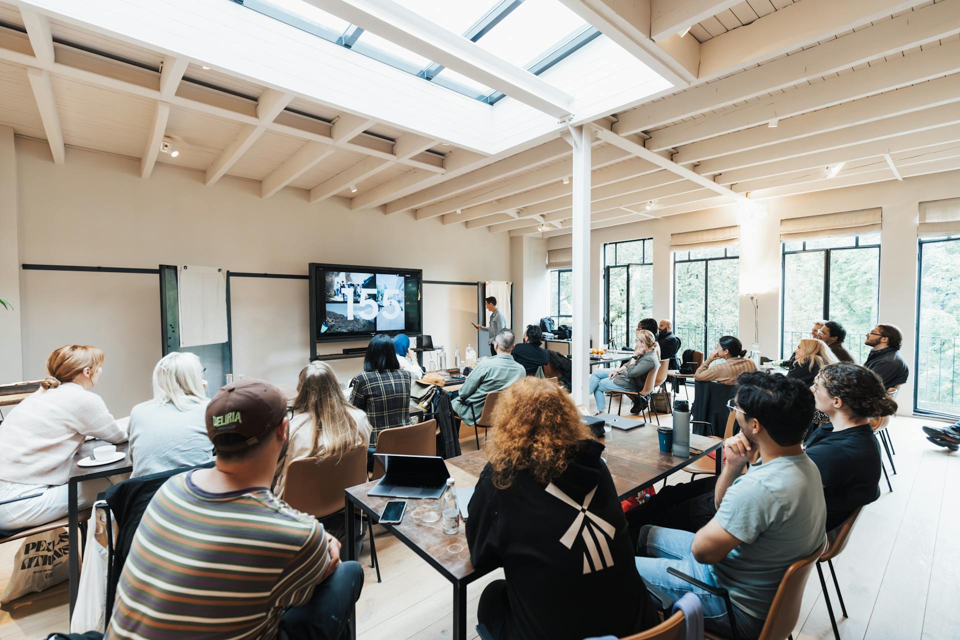 A group of adults attending a business workshop in a spacious modern room with natural light.