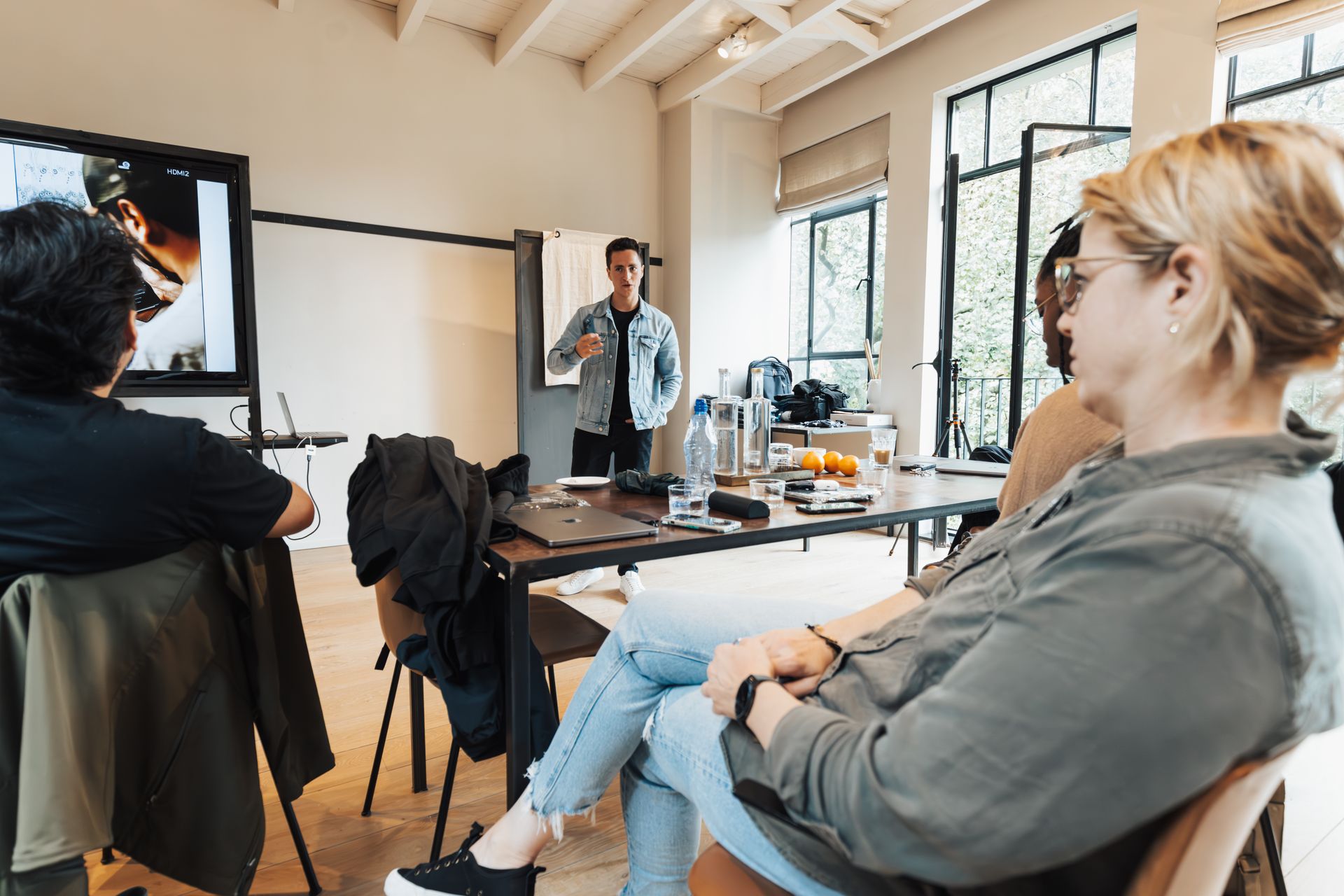 A group of professionals engaged in a dynamic presentation in a bright, modern office setting.