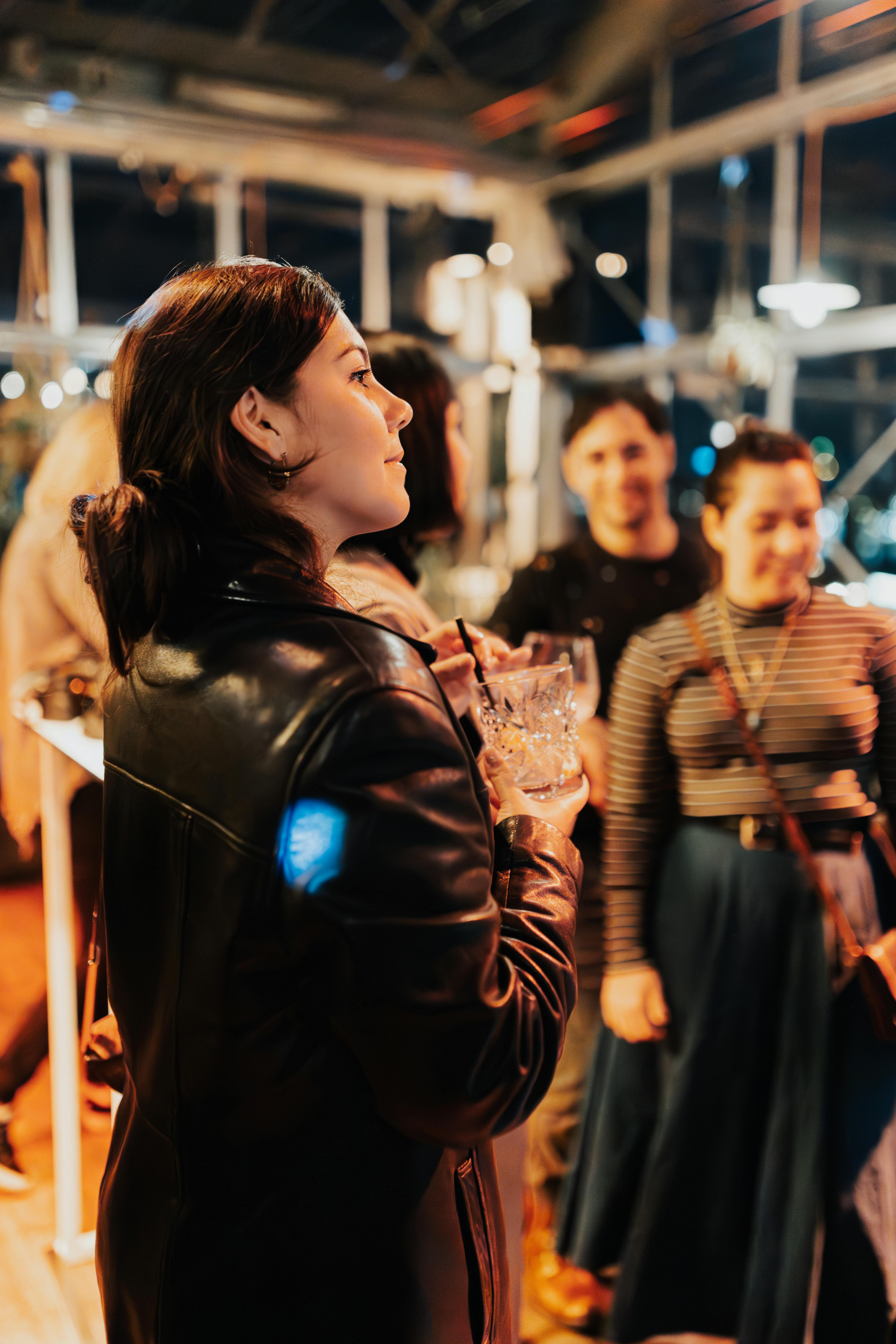 A group of adults socializing at an indoor party, capturing a lively and relaxed atmosphere.