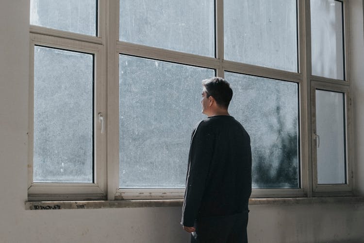 Man Looking Through Windows