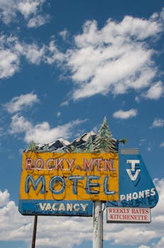Retro motel sign against vibrant sky in Lakewood, CO, perfect for travel themes.