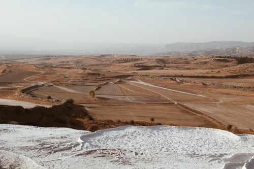 Free Aerial view showcasing Pamukkale's white thermal terraces and arid fields in Türkiye. Stock Photo