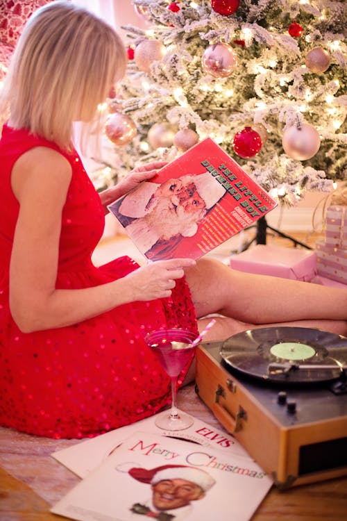 Blonde Woman in Red Dress Sitting with Christmas Vinyl Player