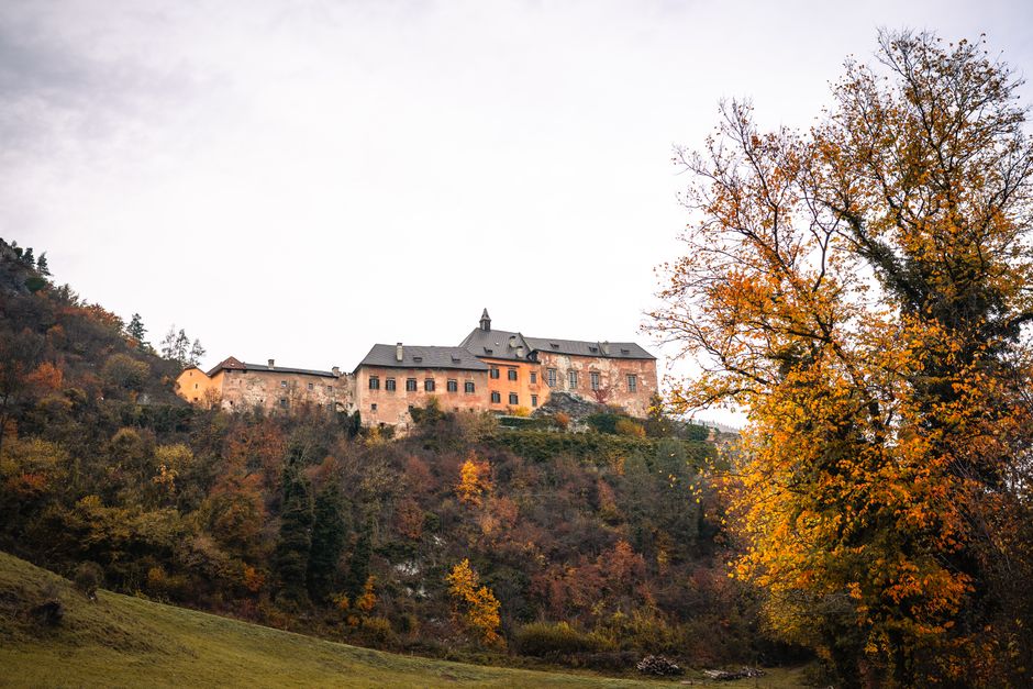 Picturesque view of a historic building surrounded by autumn foliage on a hilltop.