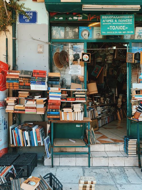 Free Discover a delightful array of used books at a quaint Athens bookstore entrance. Stock Photo