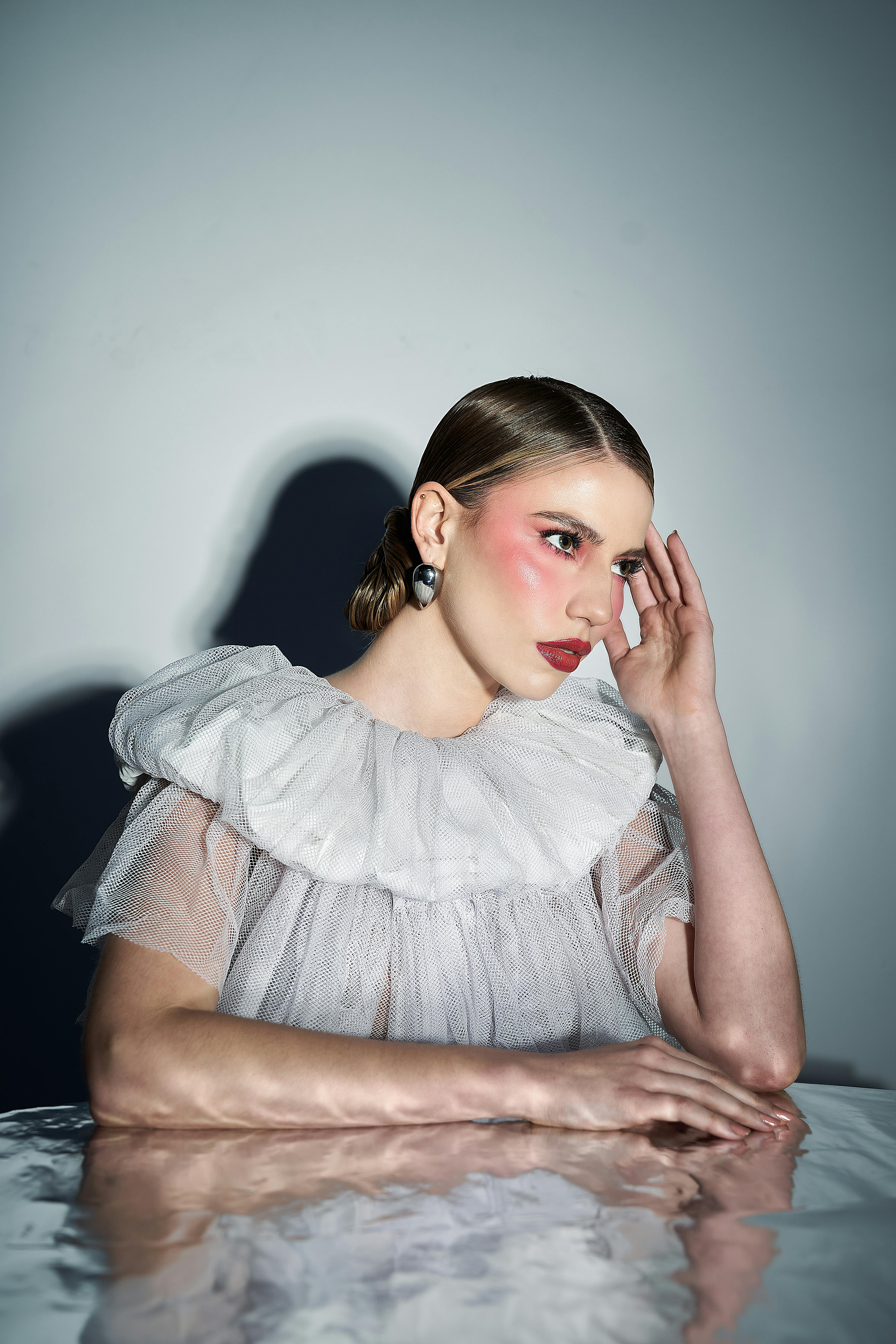Elegant portrait of a woman in Peru wearing a ruffled dress with artistic lighting.