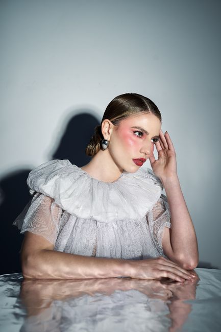 Elegant portrait of a woman in Peru wearing a ruffled dress with artistic lighting.