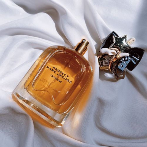 Free Close-up of Marc Jacobs perfume bottle with elegant embellishment on white fabric. Stock Photo