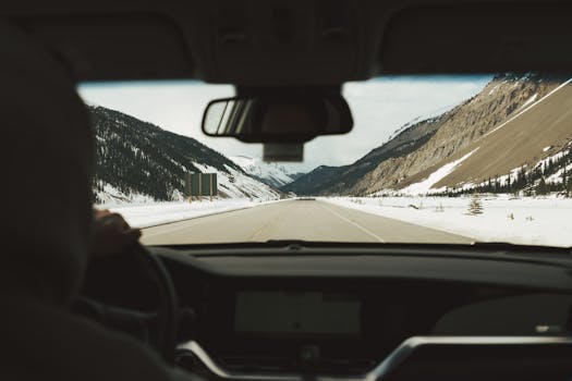 Experience a scenic winter drive through the snow-covered mountains of Banff National Park, Alberta.