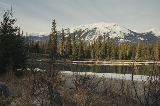 Breathtaking view of snow-capped mountains and a serene river in Jasper National Park.