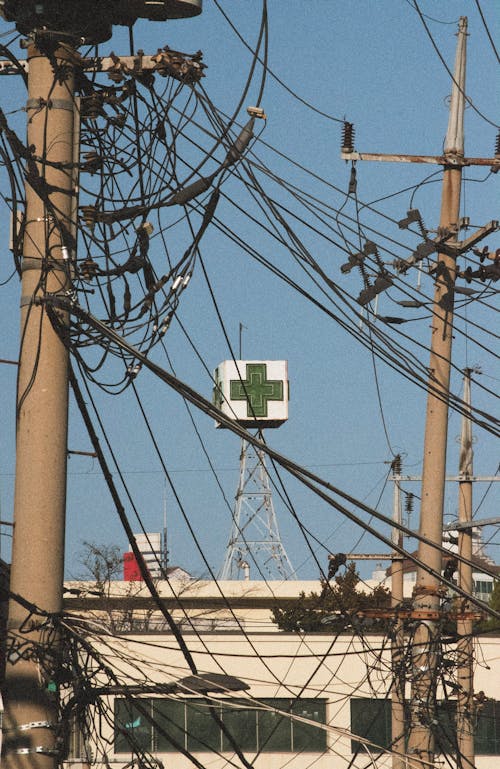 Electricity Wires and Posts in Front of Green Cross on Tower in Seoul, South Korea