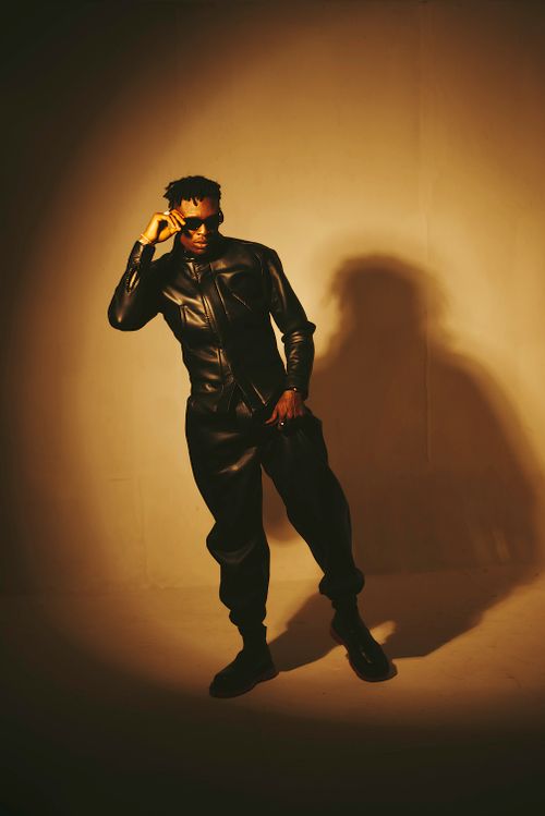 Free Fashion portrait of a man posing confidently in a leather outfit within a studio setting. Stock Photo