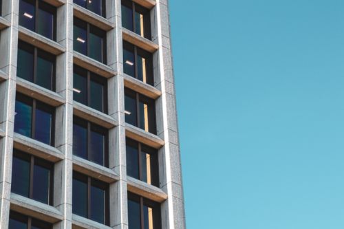 Free Close-up of a modern office building facade in Vancouver, BC, against a clear blue sky. Stock Photo