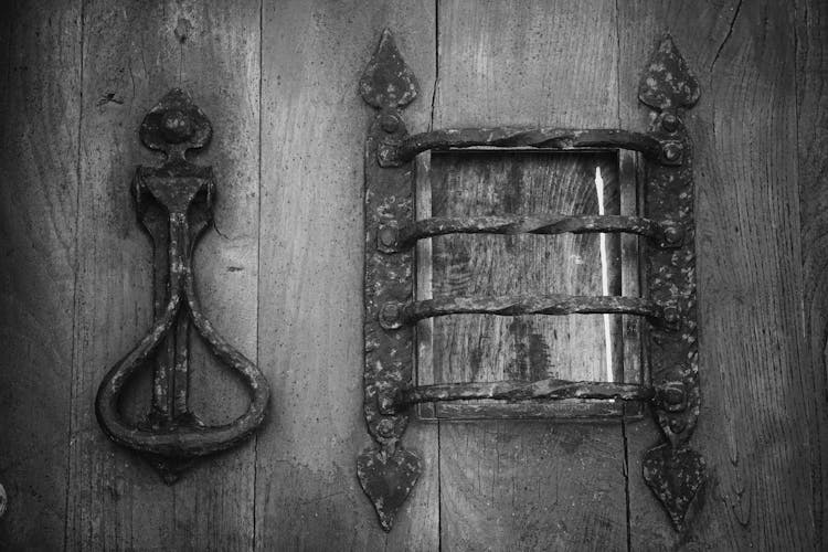 Grey Metal Knocker On Brown Wooden Door