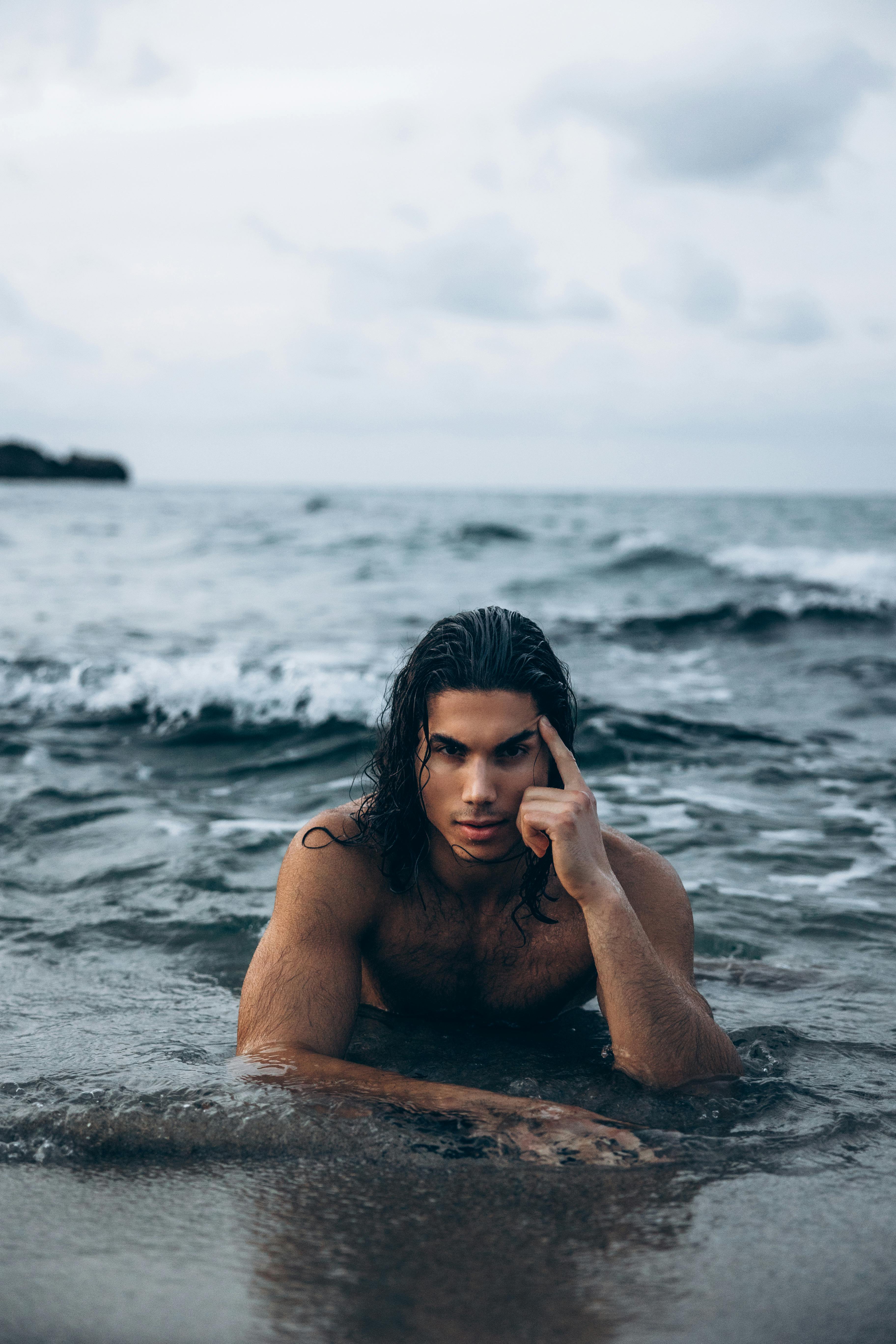 a man with long hair in the ocean