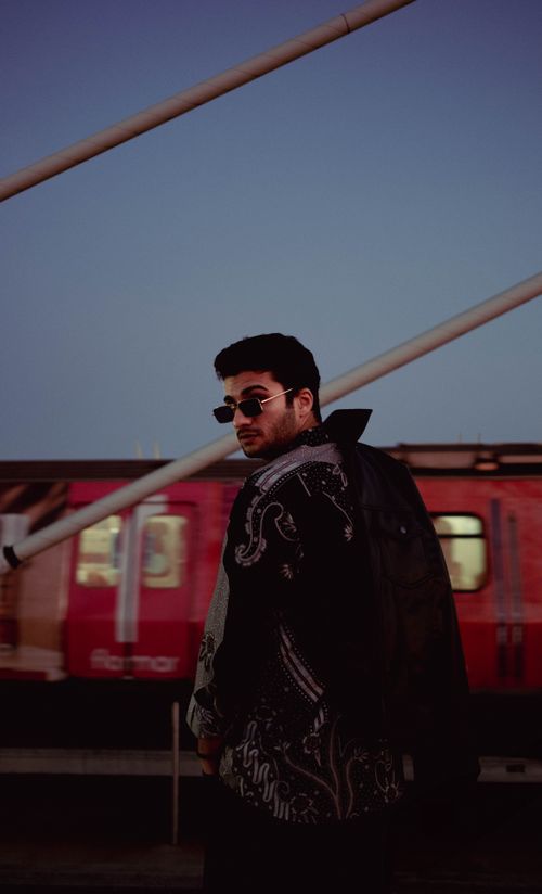 Free Fashionable man with sunglasses and stylish outfit poses at İstanbul metro station during twilight. Stock Photo