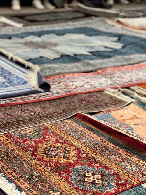 Free A variety of colorful traditional rugs on display at an outdoor market. Stock Photo