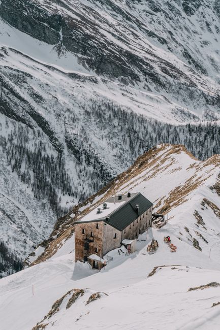 Scenic view of a mountain hut amidst snowy peaks in Mallnitz, Carinthia, Austria.