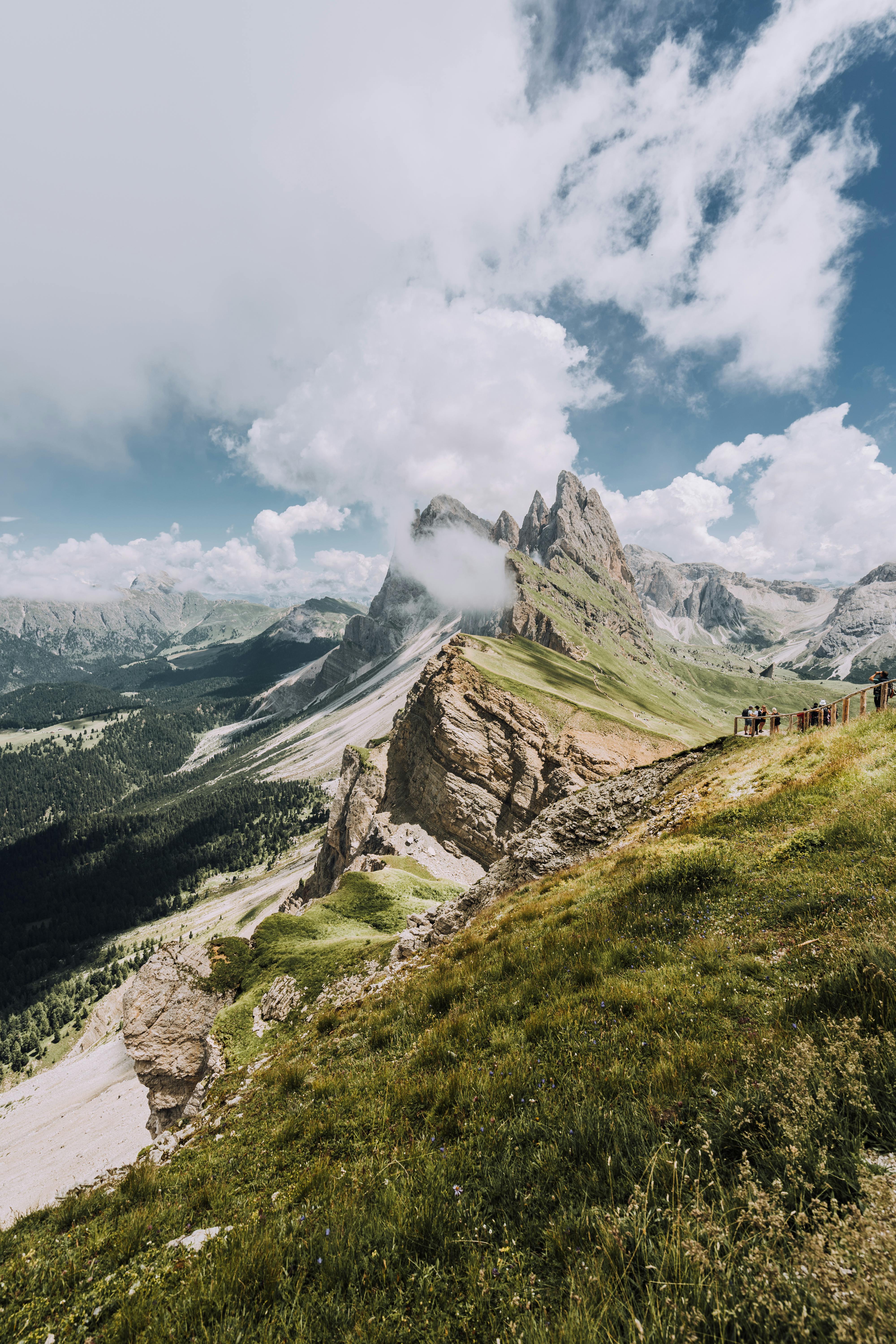 Stunning view of rocky mountains and lush valley under clear sky, perfect for nature and travel inspiration.
