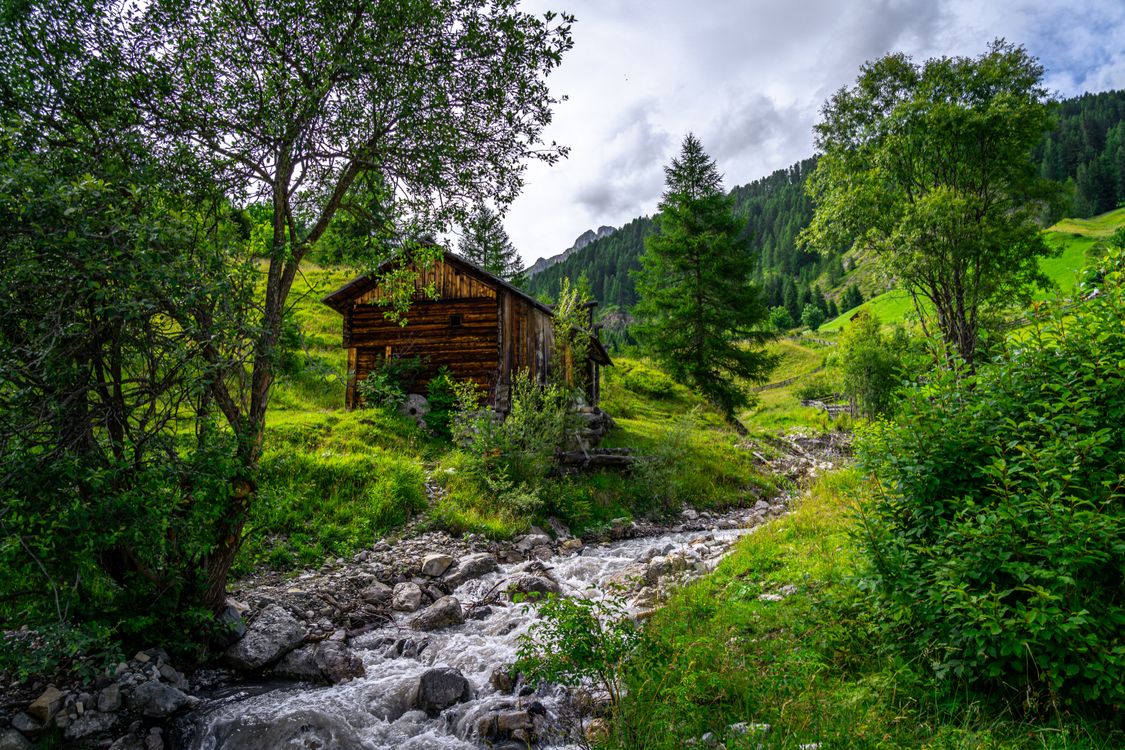 Wooden Cottage beside Stream in Mountain Landscape · Free Stock Photo