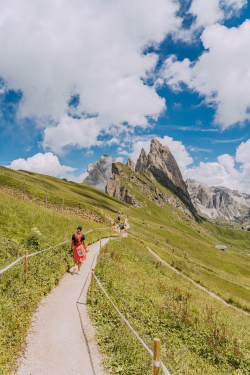 Free Scenic view of hikers on a mountain trail in the Dolomites under a bright blue sky. Stock Photo
