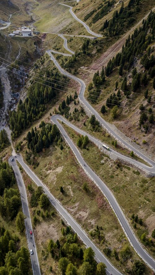 Free Aerial view of a winding mountain road surrounded by lush greenery, perfect for travel and adventure enthusiasts. Stock Photo
