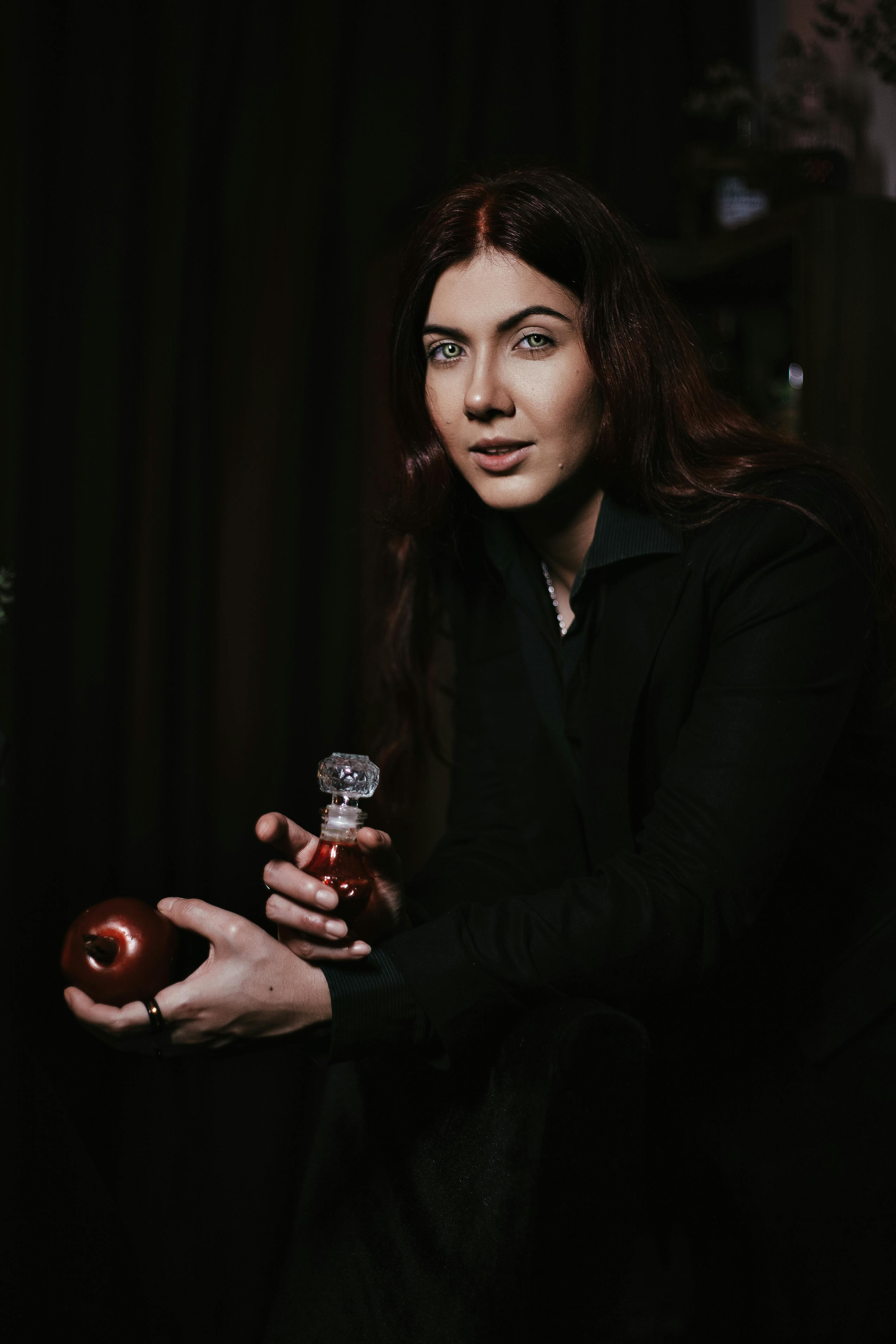 portrait of woman holding apple and bottle